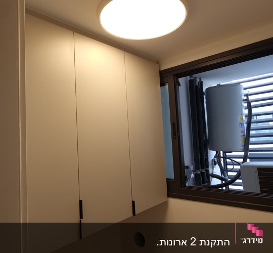 ארון עץ עם דלתות סגורות בחדר מואר